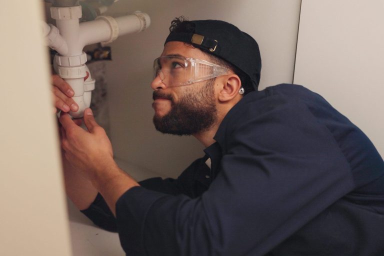 Plumber working on filter system improvement for small business in house