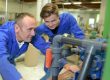 Man and apprentice looking at machinery